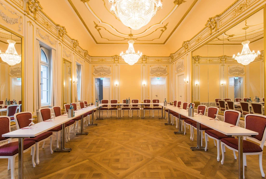 Spiegelsaal im Herrenhaus Möckern mit Kronleuchtern, Stuckdecken und U-förmig angeordneten Tischen für eine Tagung 