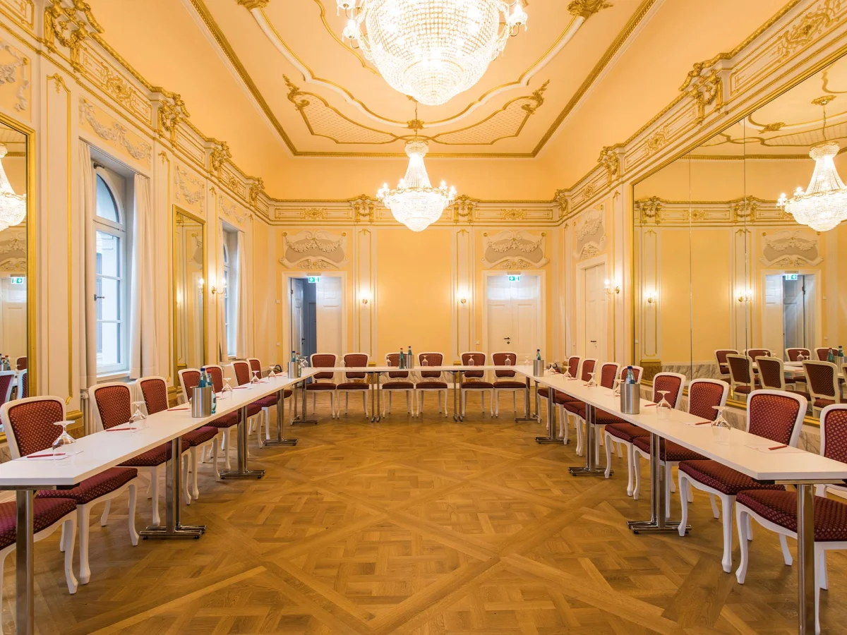 Spiegelsaal im Herrenhaus Möckern mit Kronleuchtern, Stuckdecken und U-förmig angeordneten Tischen für eine Tagung 