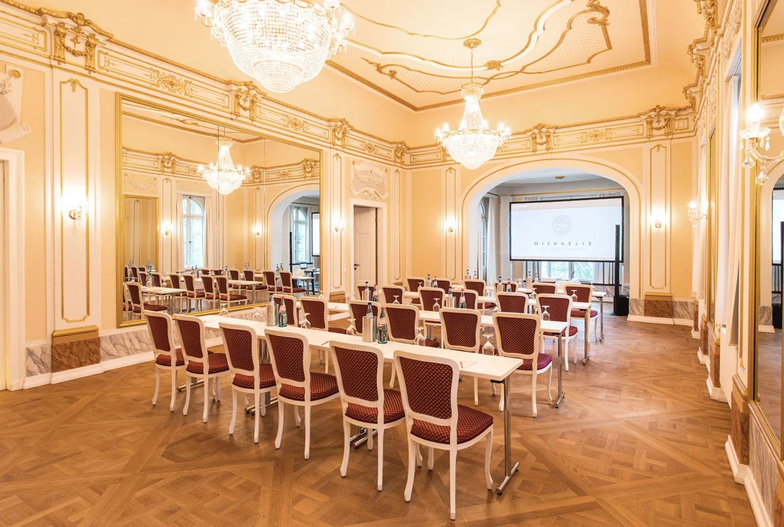 Spiegelsaal im Herrenhaus Möckern mit verzierter Stuckdecke, Kronleuchtern und parlamentarischer Bestuhlung