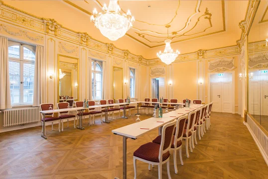 Spiegelsaal des Herrenhaus Möckern mit verzierter Stuckdecke, Kronleuchtern und U-förmiger Bestuhlung für eine Tagung